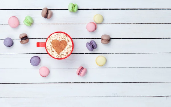 Cappuccino met hart vorm symbool en macaron — Stockfoto