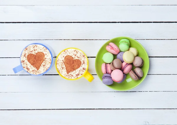 Cappuccino med hjärta form symbol och macaron — Stockfoto