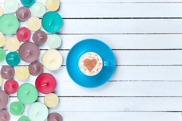 Cappuccino e candele su sfondo bianco — Foto Stock