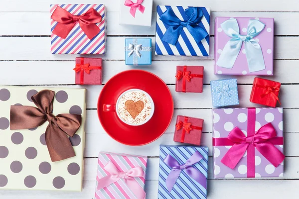 Cup of Cappuccino and gift boxes — Stock Photo, Image