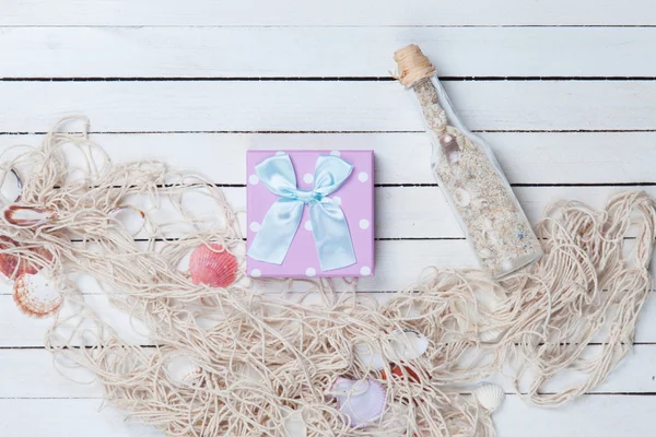 Gift box with net and bottle — Stock Photo, Image