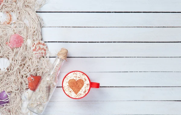 Cup of Cappuccino and net with bottle — Stock Photo, Image