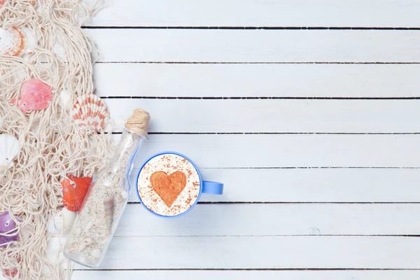 Tazza di Cappuccino e rete con bottiglia — Foto Stock