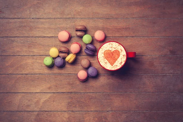 Cup en macarons op houten achtergrond — Stockfoto