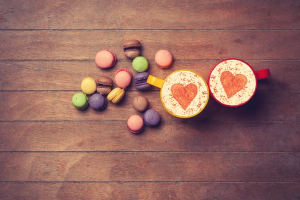 Cup and macarons on wooden background — Stock Photo, Image