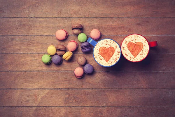 Cup and macarons on wooden background — Stock Photo, Image