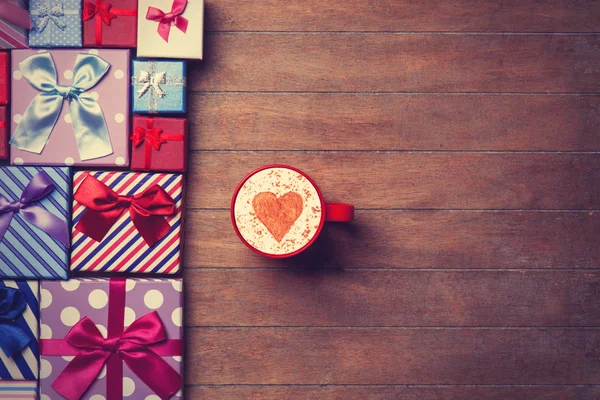 Tasse und Geschenkschachteln auf Holzgrund — Stockfoto