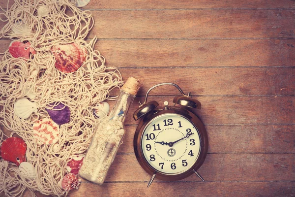 Retro alarm clock and net with shells and bottle — Stock Photo, Image