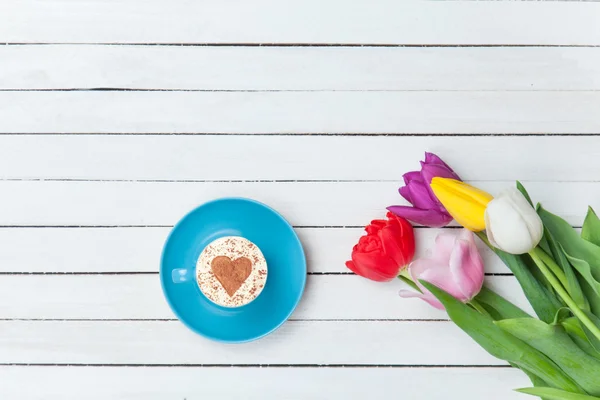 Cappuccino cerca de tulipanes — Foto de Stock