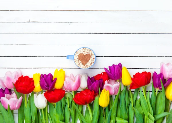 Cappuccino cerca de tulipanes — Foto de Stock