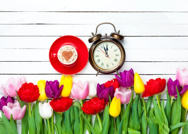 Cappuccino und Uhr in der Nähe von Blumen — Stockfoto