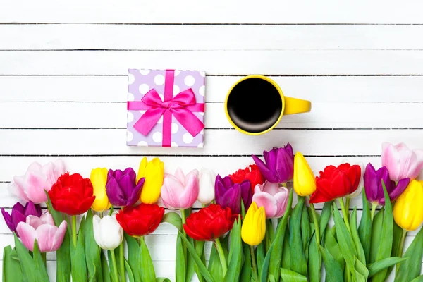Cup en cadeau vak in de buurt van bloemen — Stockfoto