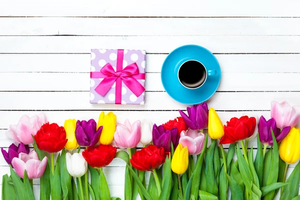 Csésze és ajándék doboz közelében virágok — Stock Fotó