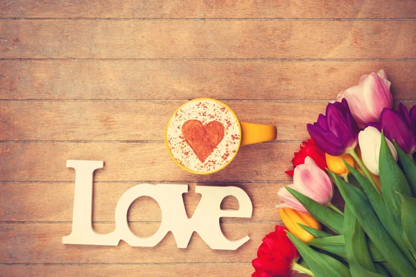 Cappuccino e palavra Amor perto de flores — Fotografia de Stock