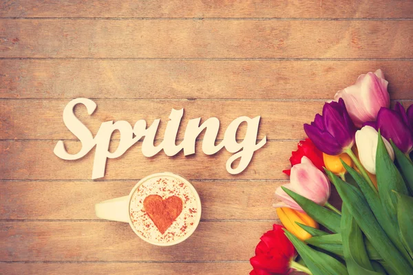 Капучино и слово Весна возле цветов — стоковое фото