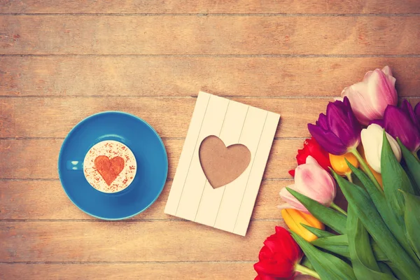 Cup and photo frame near flowers — Stock Photo, Image