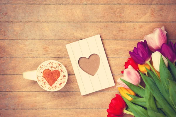 Cup and photo frame near flowers — Stock Photo, Image