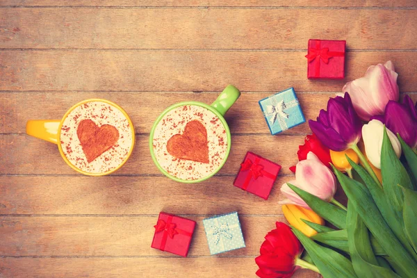 Cappuccino y regalos cerca de flores —  Fotos de Stock