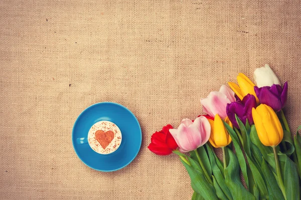 Tulips and cup of cuppuccino — Stock Photo, Image