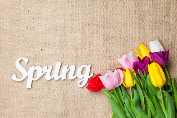 Bouquet of tulips and word Spring — Stock Photo, Image