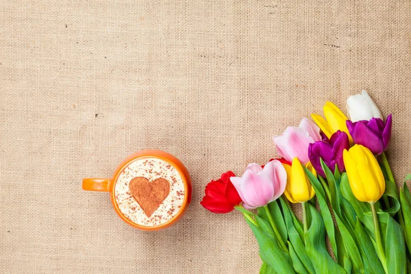 Tulipány a šálek cuppuccino — Stock fotografie