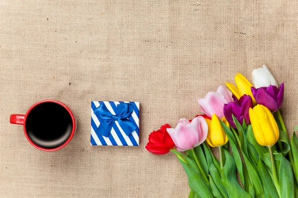 Cup of coffee and gift with flowers — Stock Photo, Image