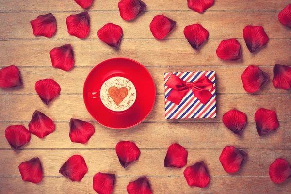 Cup and petals with gift box — Stock Photo, Image