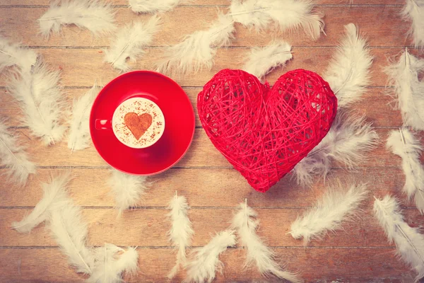 Juguete corazón y taza de café con forma de corazón y plumas — Foto de Stock