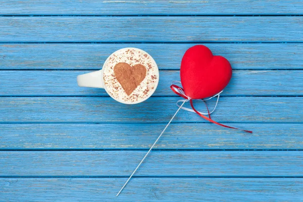 Kopje Cappuccino met hart vorm symbool en speelgoed — Stockfoto