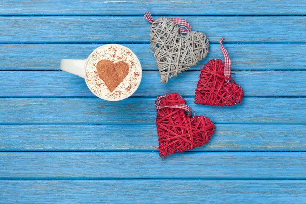 Copa de Cappuccino con símbolo de la forma del corazón y juguetes — Foto de Stock