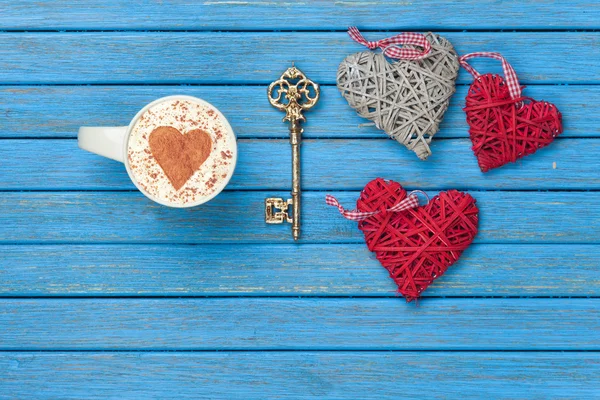 Cup of Cappuccino with heart shape symbol, key and toys — Stock Photo, Image