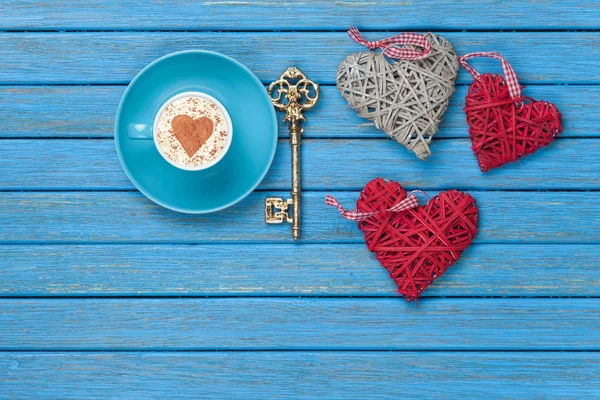 Cup of Cappuccino with heart shape symbol, key and toys — Stock Photo, Image