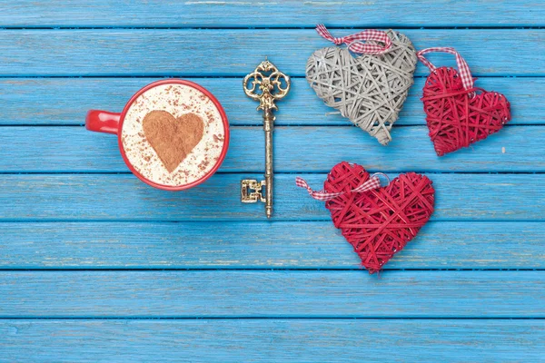 Copa de Cappuccino con símbolo de forma de corazón, llave y juguetes — Foto de Stock
