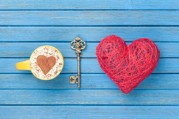 Filiżankę Cappuccino z symbol kształt serca, klucz i zabawki — Zdjęcie stockowe