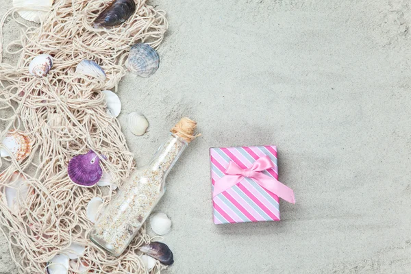 Net, shells with bottle and gift box — Stock Photo, Image