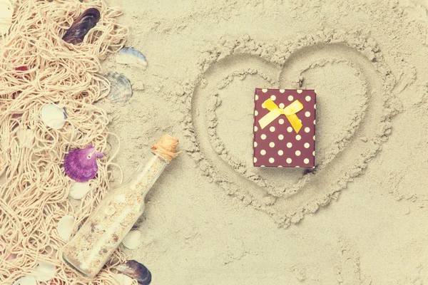 Net, shells with bottle and gift box — Stock Photo, Image