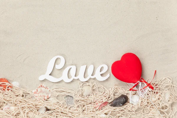 Word Love and toy heart shape on net and shells — Stock Photo, Image