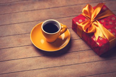 Ahşap bir masa kahve ve hediye kutusunda fincan.