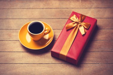 Ahşap bir masa kahve ve hediye kutusunda fincan.