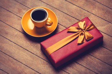 Ahşap bir masa kahve ve hediye kutusunda fincan.
