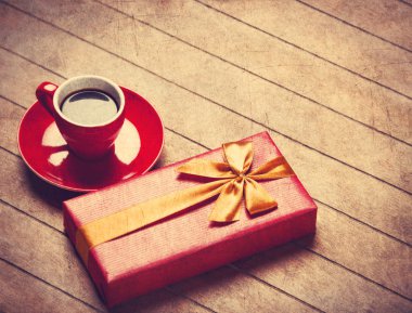 Ahşap bir masa kahve ve hediye kutusunda fincan.