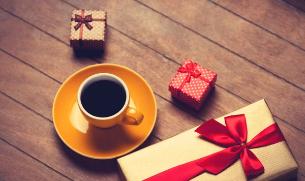 Kopp kaffe och gåva ruta på ett träbord. — Stockfoto