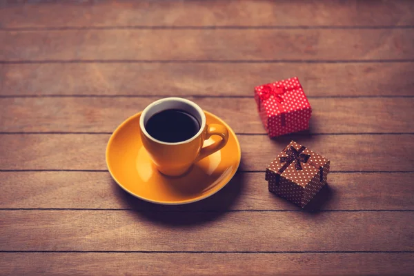 Xícara de café e caixa de presente em uma mesa de madeira . — Fotografia de Stock