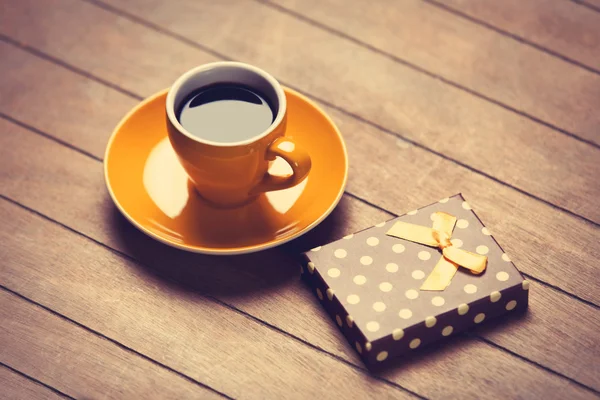 Tasse Kaffee und Geschenkbox auf einem Holztisch. — Stockfoto