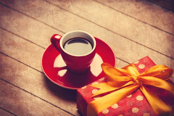 Tazza di caffè e confezione regalo su un tavolo di legno . — Foto Stock