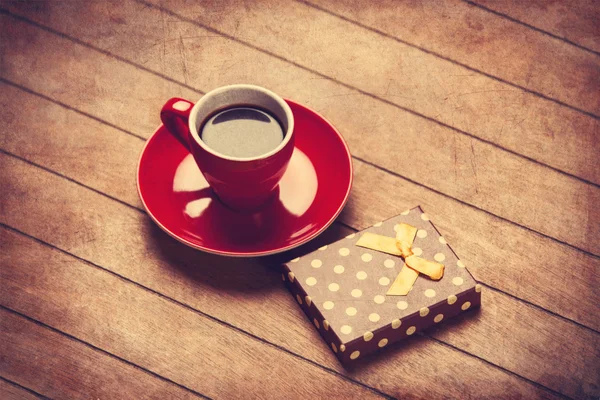 Kopje koffie en cadeau doos op een houten tafel. — Stockfoto