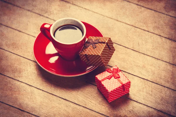 Taza de café y caja de regalo en una mesa de madera . — Foto de Stock