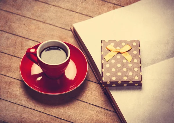 Taza de café y caja de regalo con libro en una mesa de madera — Foto de Stock