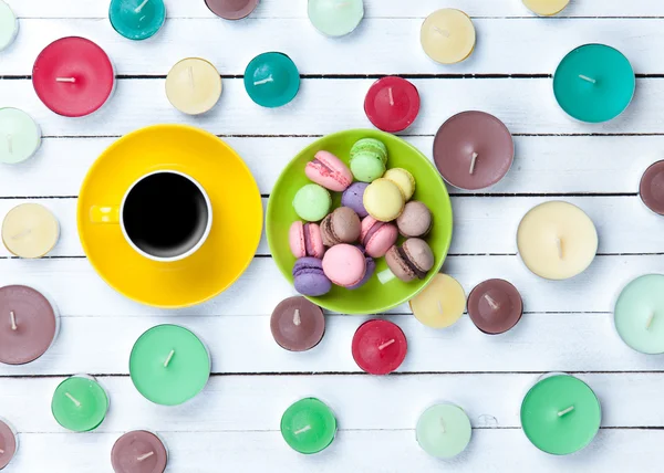 Cup of coffee and candles with macarons — Stock Photo, Image