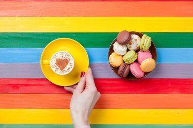 Kadın elleri bir fincan kahve tutuyor.